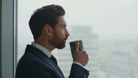 company worker drinking hot beverage at window close up. manager creating ideas.
