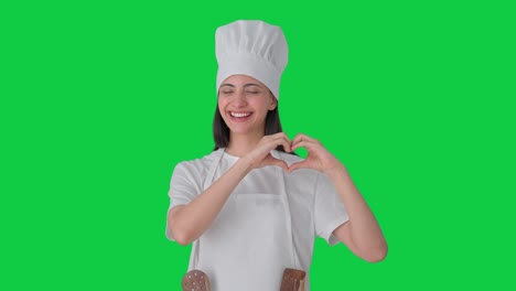 feliz india mujer chef profesional haciendo corazón signo pantalla verde