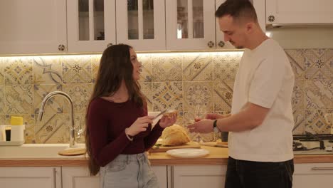 una pareja enamorada haciendo un sándwich en la cocina de la sala de estar