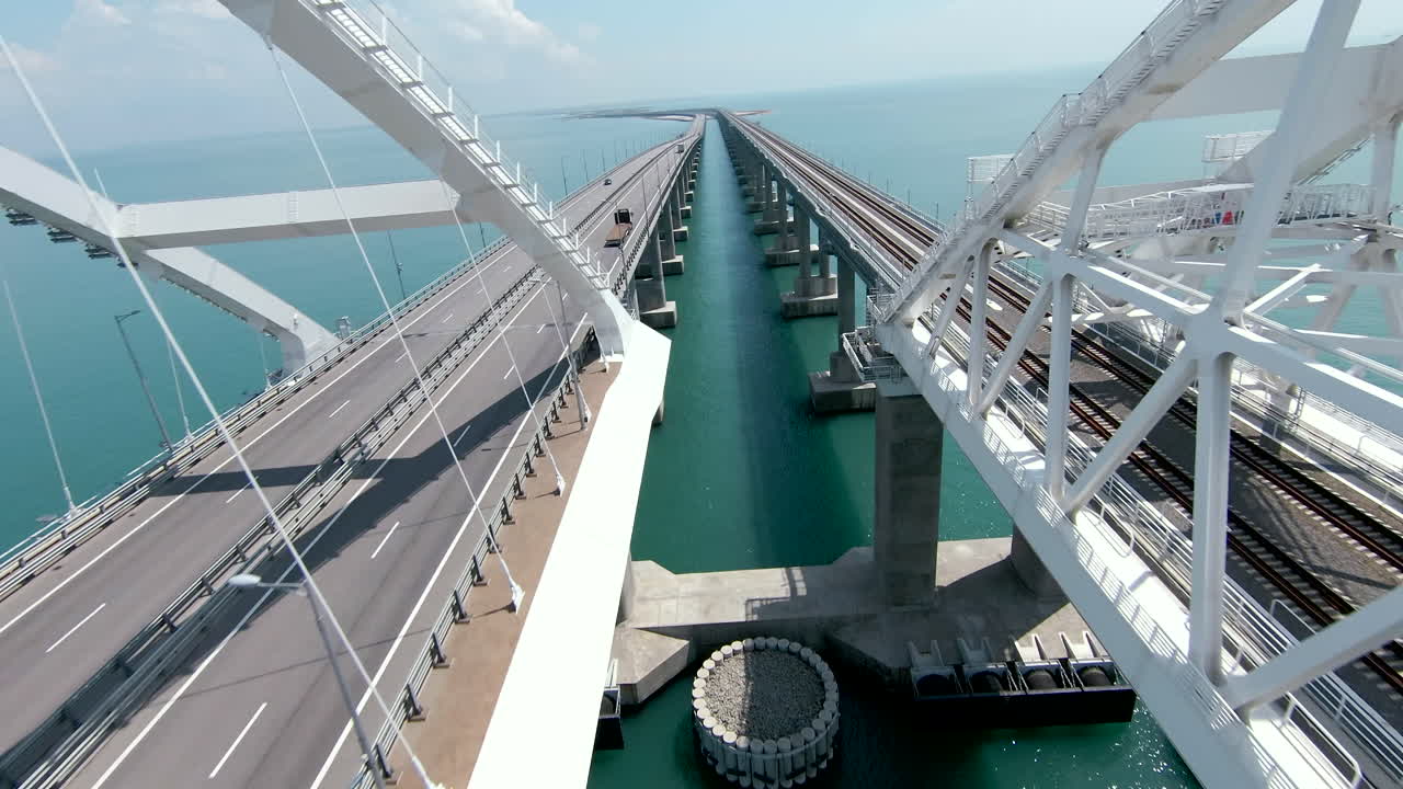 도로 와 열차 트랙 을 가진 물 위 의 긴 스 다리