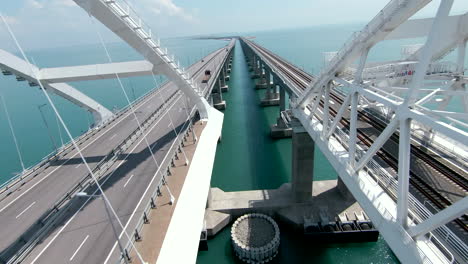 long span bridge over water with road and train tracks