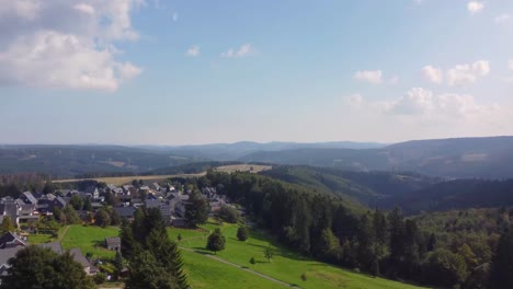 Drone-flight-in-summer-over-the-Thuringian-Forest-and-the-small-community-of-Masserberg