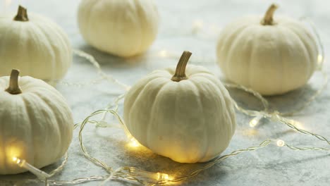 calabazas blancas con guirnaldas en la mesa