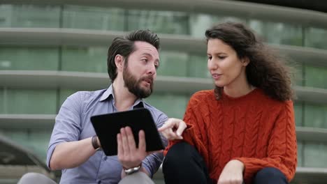 happy couple using digital tablet outdoor