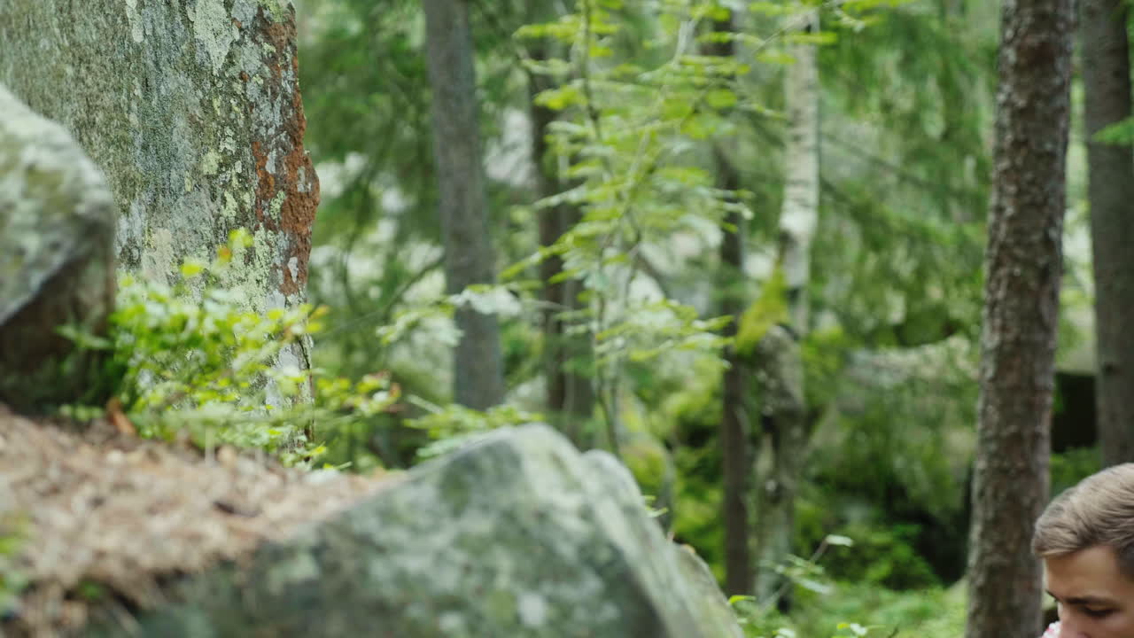 un hombre decidido con una mochila sube a un concepto de roca: la búsqueda de un objetivo 4k video