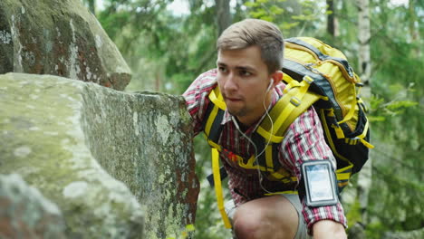 un hombre decidido con una mochila sube a un concepto de roca: la búsqueda de un objetivo 4k video