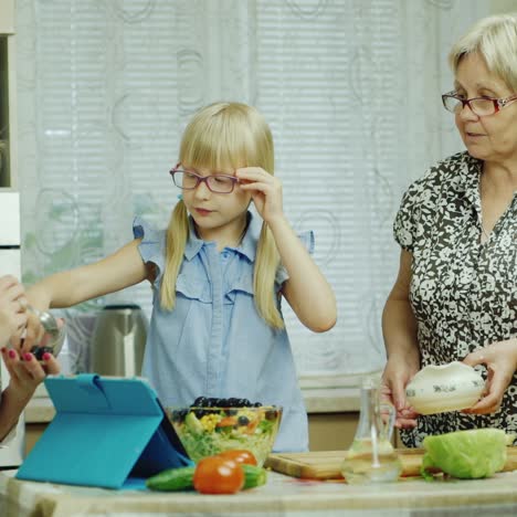 grandmother mother and granddaughter cook together a salad in the kitchen 1