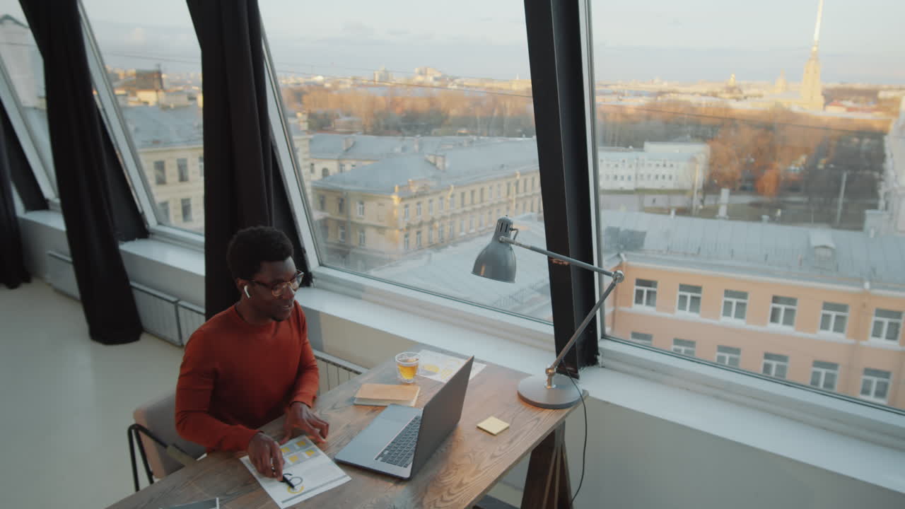 African American Businessman Web Conferencing on Laptop in Rooftop Office