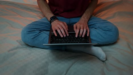 persona que trabaja en la computadora portátil en la cama por la noche