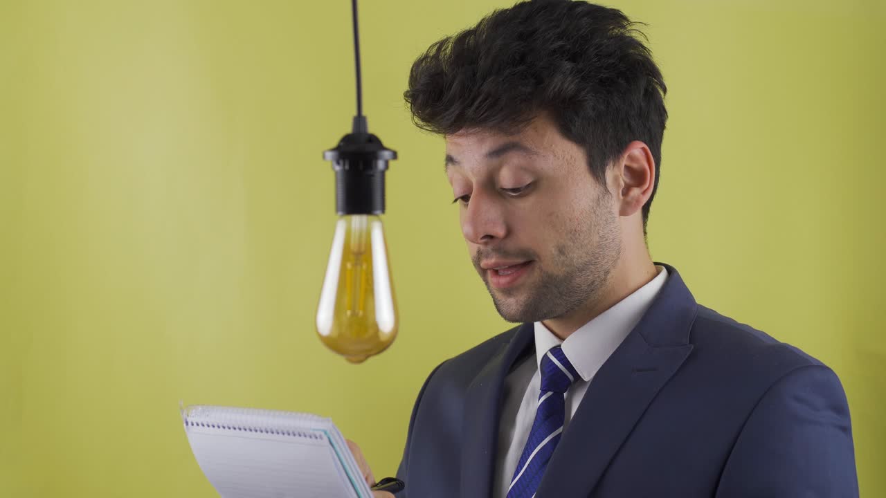 el hombre de negocios que toma notas genera una nueva idea. lámpara de ideas.