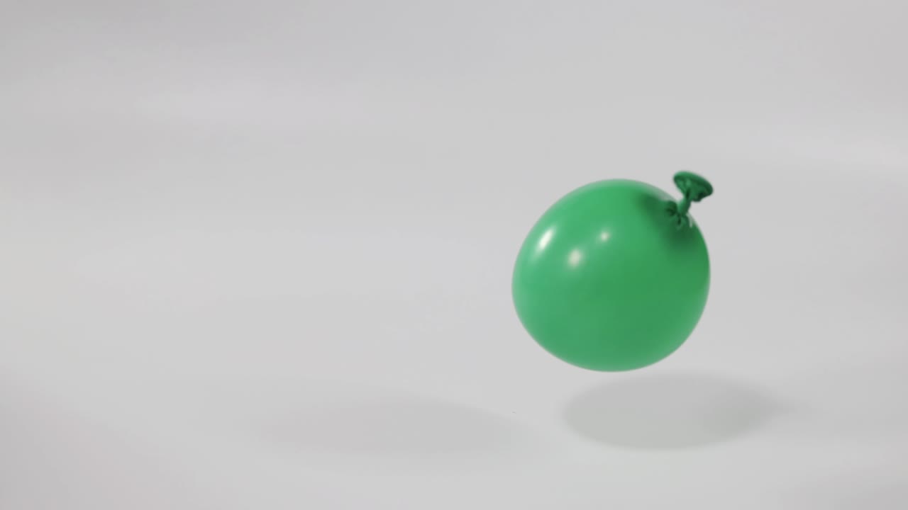 un globo verde cae y se deforma