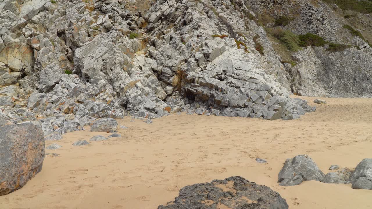 piedras de forma cúbica de color gris en la playa cerca de las cuevas de la montaña gruta da adraga
