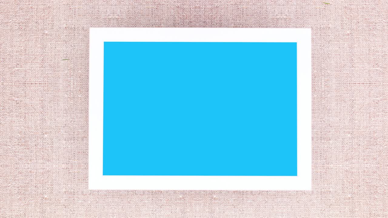 White frame with blue screen and pine branches with silver ornaments. Stop motion