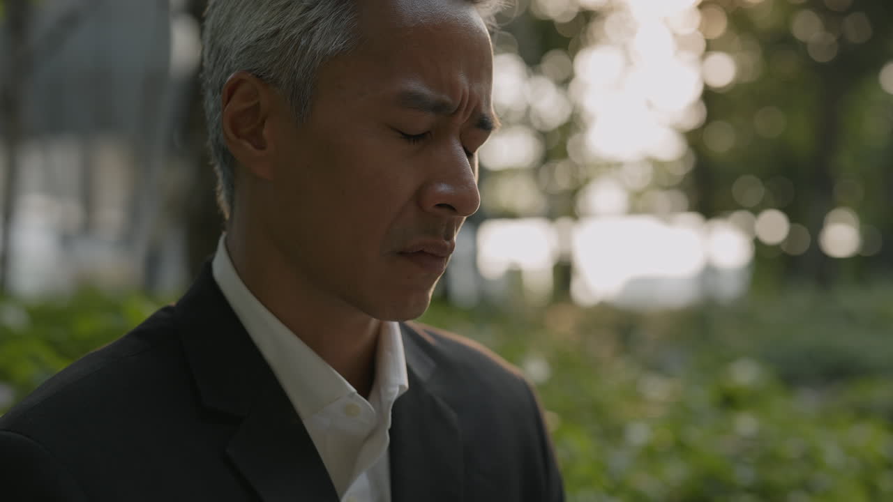 戶外沉思中的亞洲商務人士特寫。