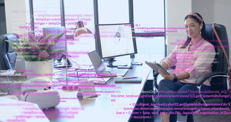 Una sviluppatrice software scorre un tablet rivedendo il codice e attiva una sovrapposizione di codice rosa in ufficio