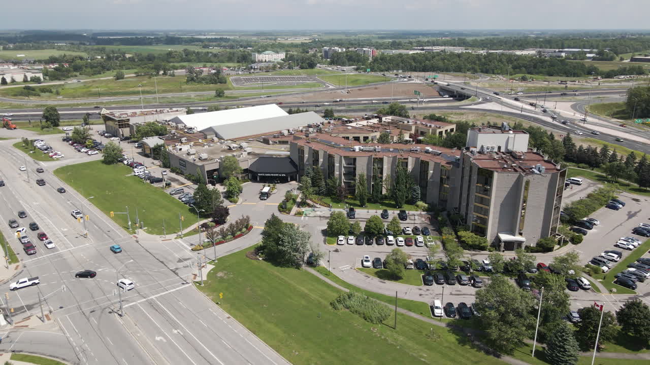Slow motion drone pullback from apartment office building located off of highway offramp by large road intersection