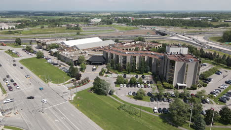 slow motion drone pullback from apartment office building located off of highway offramp by large road intersection