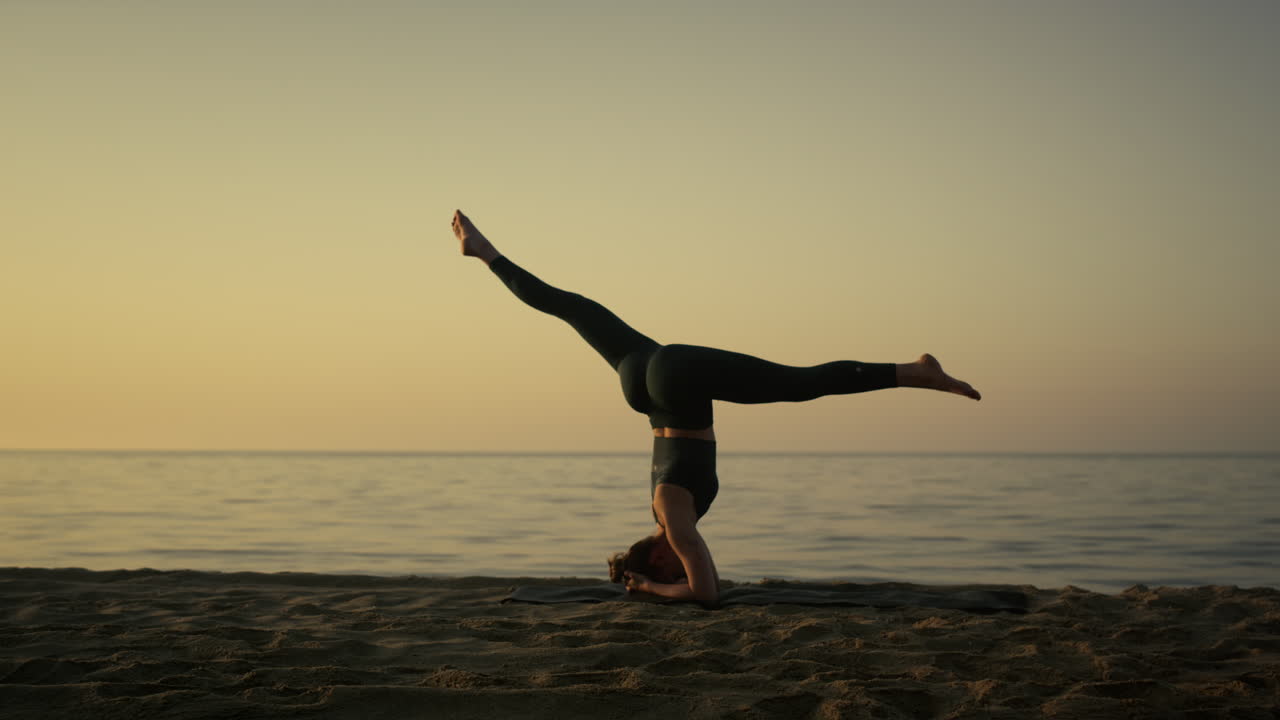 deportista en forma realizando cuerda de pie sobre la cabeza temprano en la mañana al aire libre.