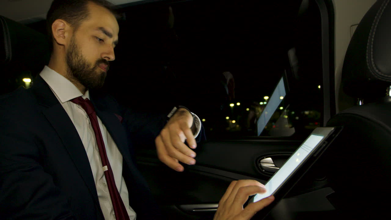 un hombre de negocios cansado en el asiento trasero de su limusina yawing