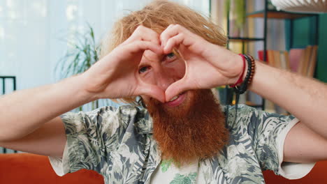 happy caucasian man guy makes symbol of love showing heart sign to camera express romantic feelings