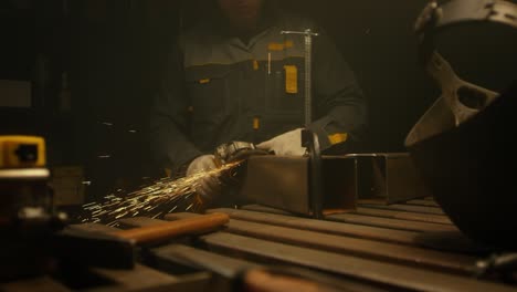 trabajador moliendo hierro. interior de la fábrica de la industria pesada con trabajador usando una molienda angular con muchas chispas afiladas. rueda eléctrica moliendo en tubos de acero en la fábrica. cámara lenta. video 4k. filmado en rojo