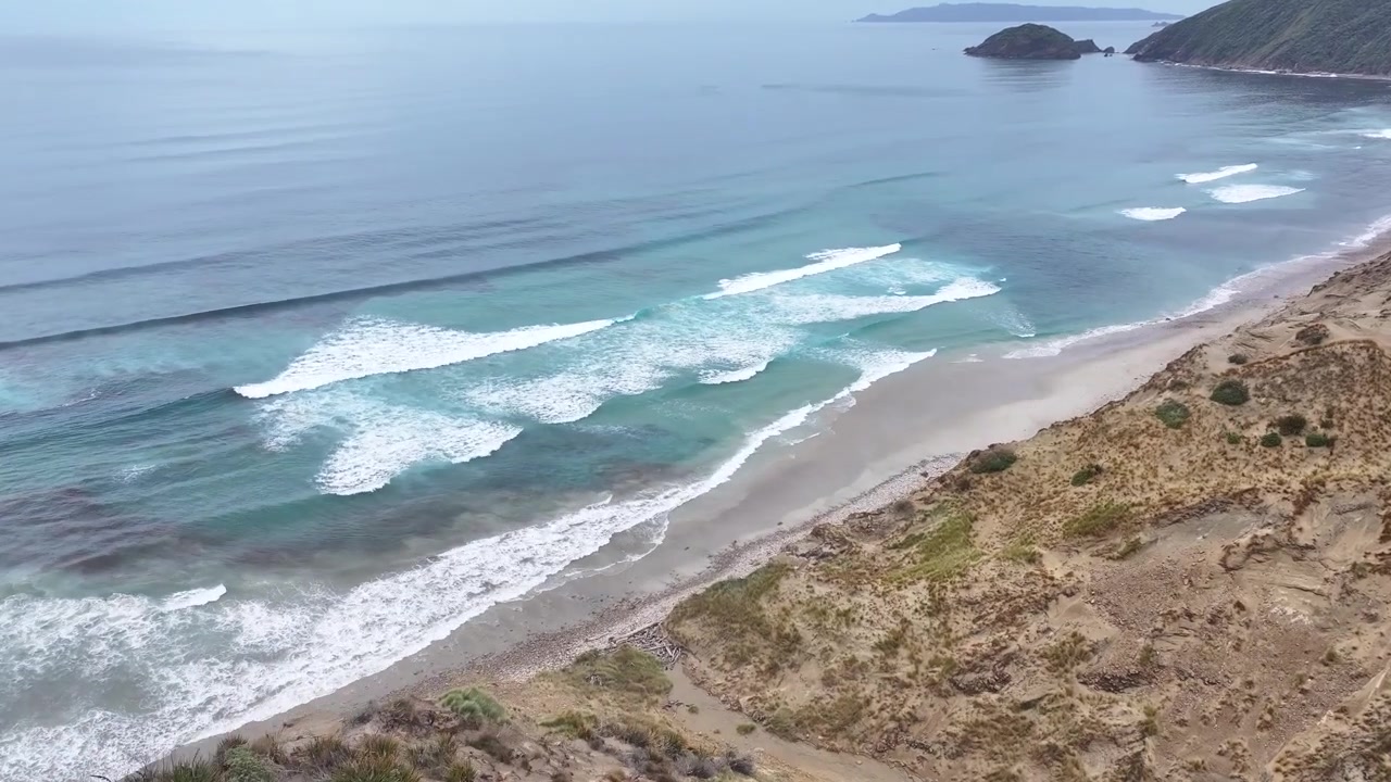 Hikers on sand dune in Stewart Island. rugged coastal scenery. Explore remote places. Drone