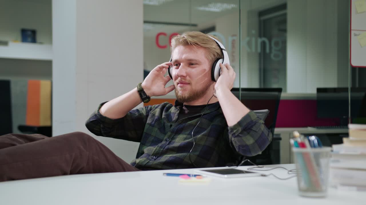 un joven usando una tableta y escuchando música