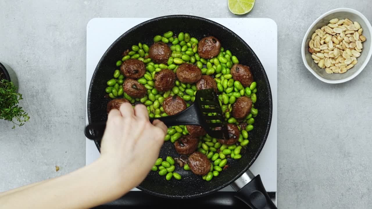 녹색 콩 과 고기 볼 을 요리 하는 여자