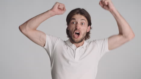 caucasian happy man in front of camera on gray background.