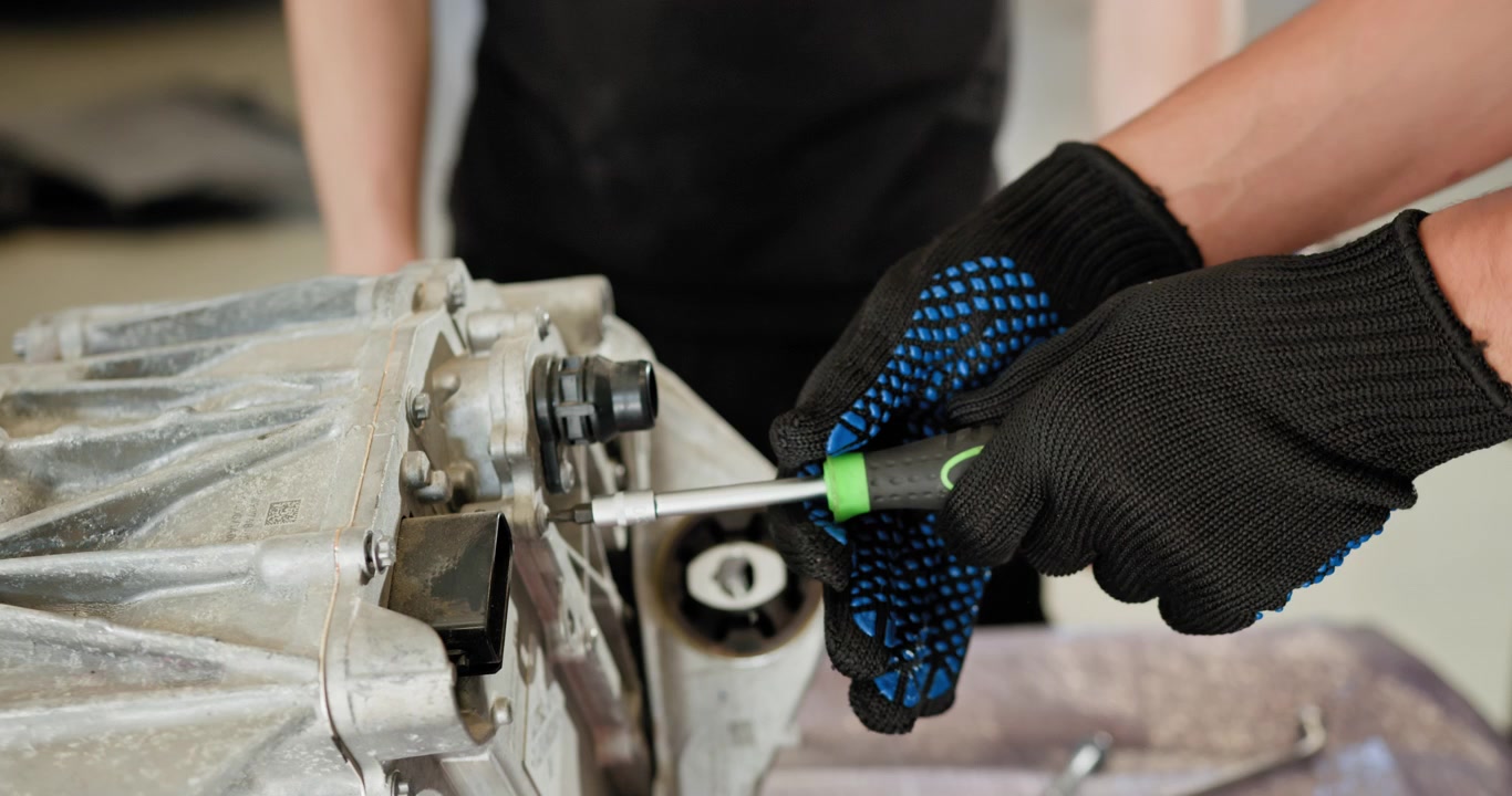 Disassembled electric car engine a mechanic repairing a disassembled electric car engine focusing on