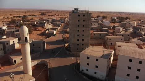 Toma-Aérea-De-Un-Dron-Que-Vuela-Desde-El-Primer-Plano-De-Un-Edificio-Antiguo-Que-Revela-Una-Antigua-Ciudad-Vacía-En-El-Desierto-En-Palestina-Cerca-De-Gaza