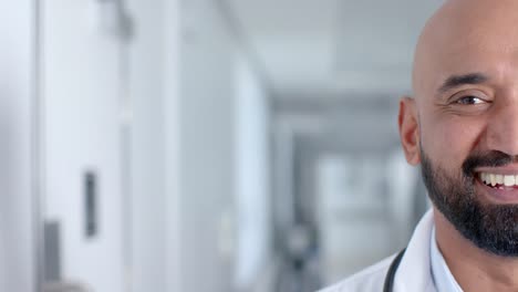 Portrait-of-happy-biracial-male-doctor-wearing-lab-coat,-smiling,-copy-space,-slow-motion