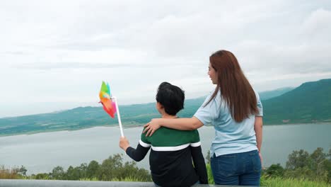 a progressive woman and her son are on vacation at the natural beauty of a lake