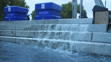 el agua fluye fuertemente en las escaleras de montpellier plaza de la comedia francia, clima húmedo