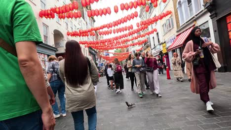 people walking under red lanterns in chinatown