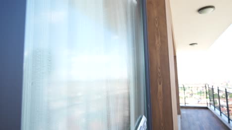mujer limpiando la ventana en el balcón