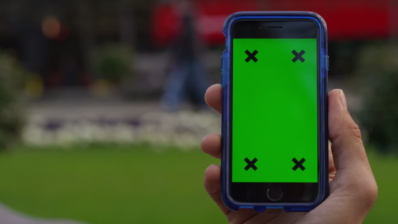 pantalla verde de la llave de croma del teléfono celular con la mano