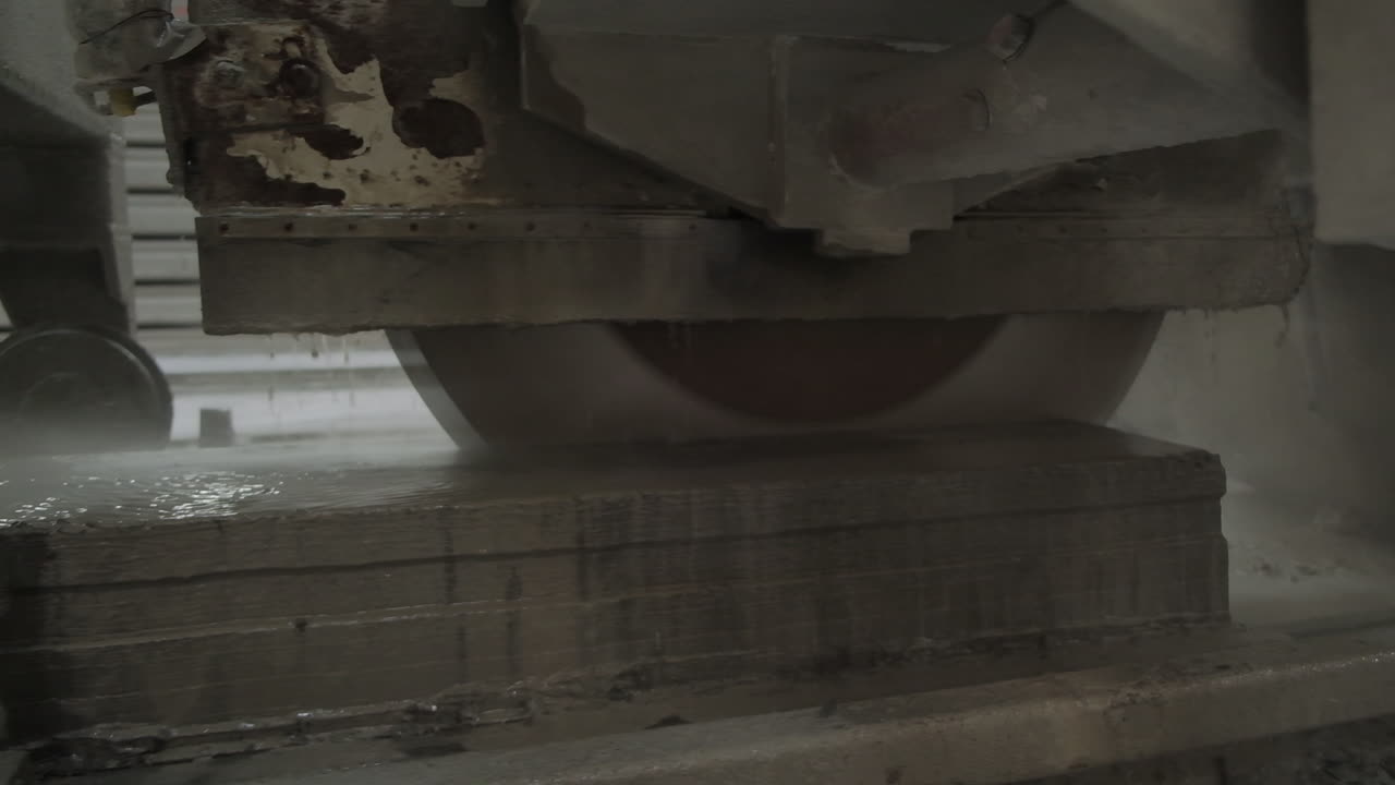 Huge round blade cutting the armored concrete plate. Drops of water dripping from the working mechanism for cooling machine.