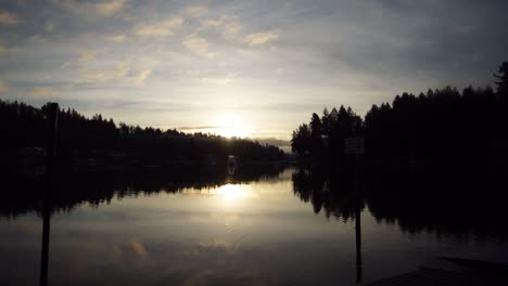 hyper time lapse left to right of sunrise over wollochet bay near gig harbor, washington, streaming clouds, golden sky, reflection