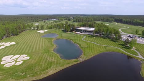 aerial view of a golf course with a modern clubhouse