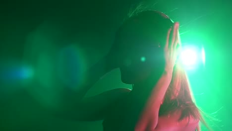 woman in profile view with headphones and vibrant lighting