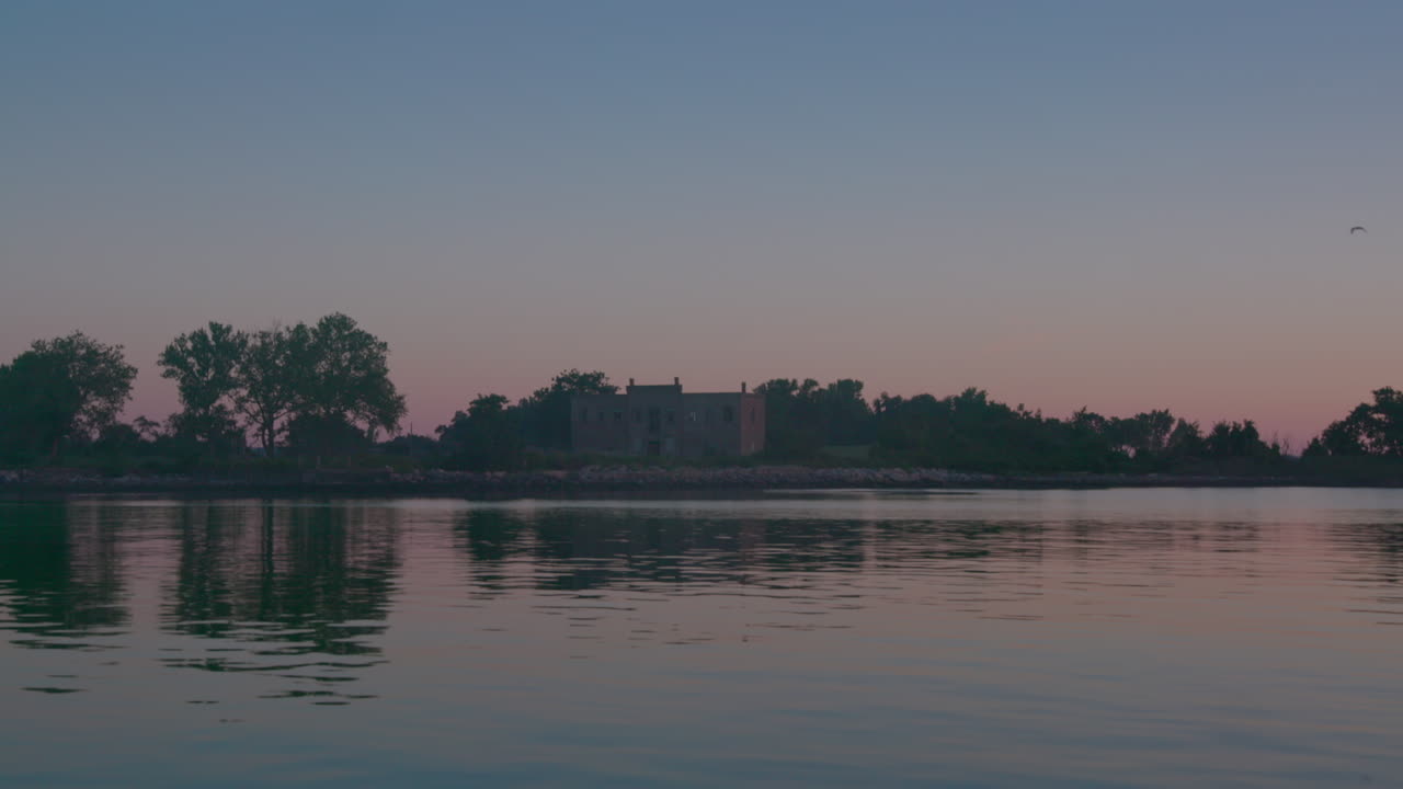 cámara lenta en la isla hart, lugar de entierro solemne para muertos no identificados, desde el agua, puesta de sol en la noche
