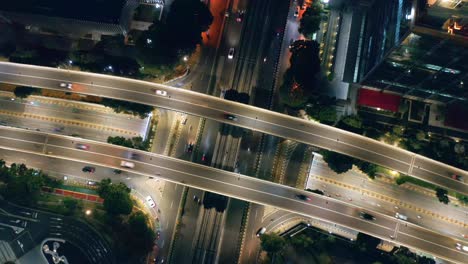 Top-down-aerial-view-of-huge-intersection-with-overpass-road-at-night---Jakarta,-Indonesia