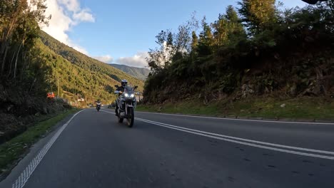 biker on adventure motorcycle riding on rural asphalt road. northern chilean patagonia. golden hour