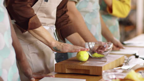 chef rolling lemon and talking to students during cooking class