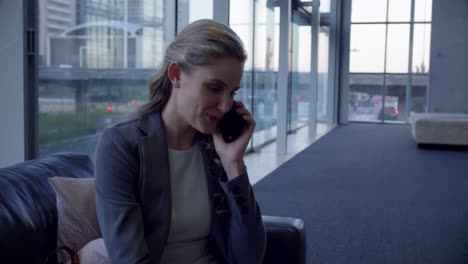 businesswoman talking on mobile phone in the lobby at office 4k