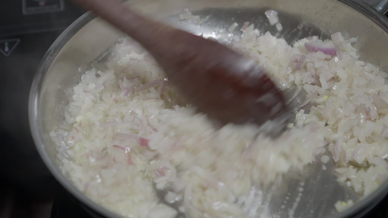 freír la cebolla en una sartén en una estufa de inducción, para preparar la mantequilla de café de parís