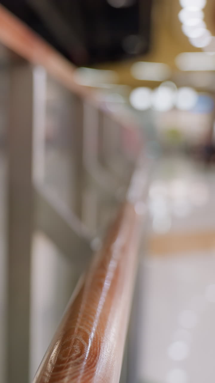 una vista sfocata di una zona sciistica con persone che sciano sullo sfondo, evidenziando la ringhiera lucidata e l'ambiente attivo della zona sciistica