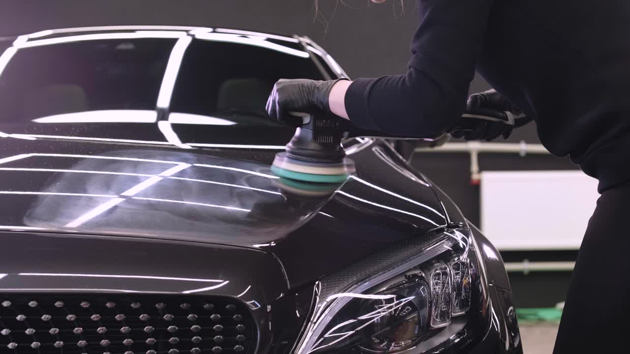 trabajador pulir un coche negro. detalles del coche - mujer están usando maquinaria pulidores de automóviles mantenimiento para eliminar marcas reparación de acuerdo con la superficie de la pintura del coche antes de contin