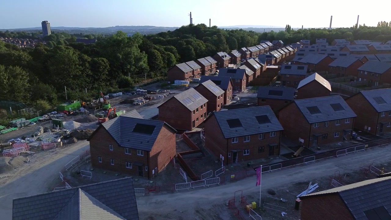 Luftfoto af byggeplads for billige boliger over ufærdigt boligområde